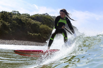 Female sup surfer on a wave
