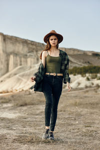 Portrait of young woman standing on field