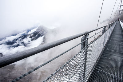 Narrow footbridge along snowed mountains