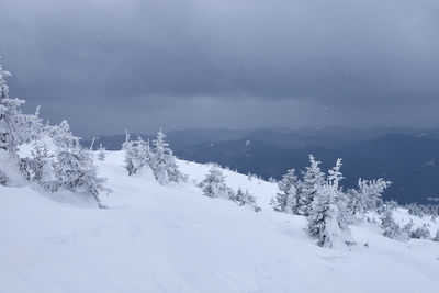 Scenic view of snow covered mountains against sky