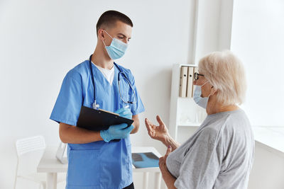 Doctor wearing mask examining patient at clinic