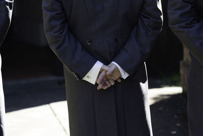 Midsection of man in suit standing outdoors