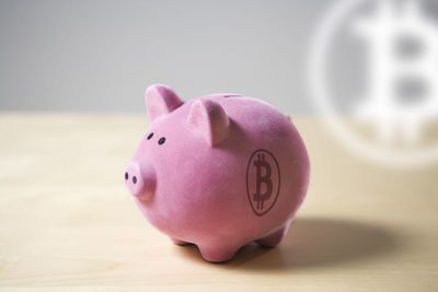Pink piggybank with bitcoin crypto currency symbol