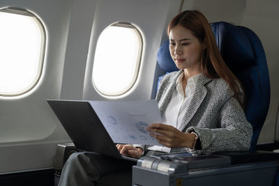 Young woman using laptop while sitting in car