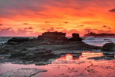 Scenic view of sea against orange sky