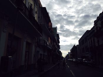 Buildings in city against cloudy sky