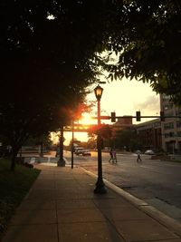 Silhouette of people in city at sunset