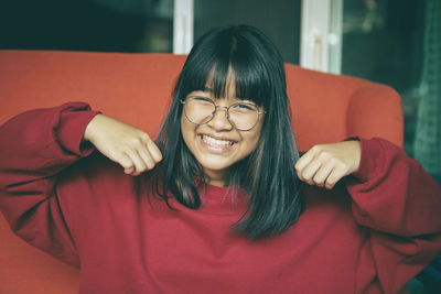 Toothy smiling face of asian teenager at home living room