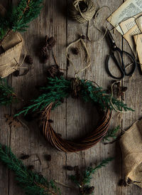 Directly above view of wreath by scissors and string on table