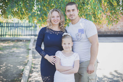 Young parents with daughter laughing in the backyard in autumn