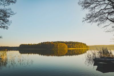 Scenic view of lake against clear sky at sunset