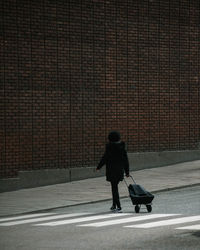 Rear view of woman walking on street in city