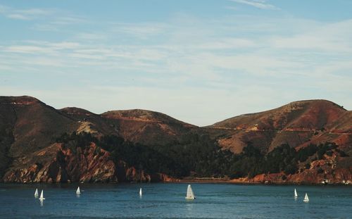 Scenic view of sea and mountains against sky
