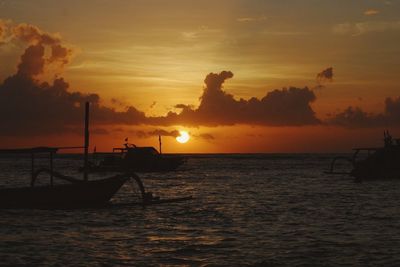 Silhouette boat in sea against sky during sunset