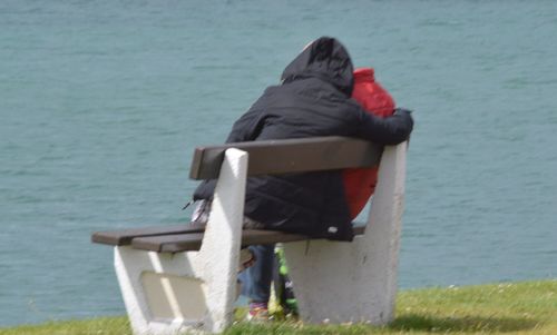 Rear view of a man overlooking calm sea