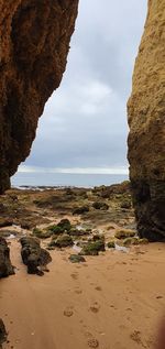 Rock formation on beach against sky