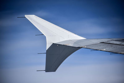 Low angle view of airplane wing against sky