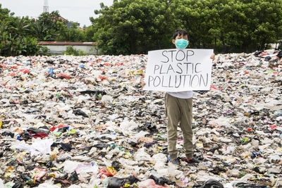 Boy holding poster on garbage
