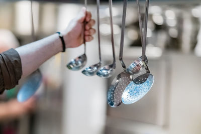 Ladles hanging from the rack in a restaurant.