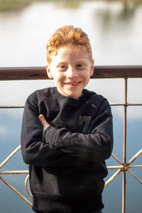 Portrait of smiling boy by railing