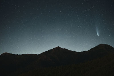 Scenic view of silhouette mountains against sky at night