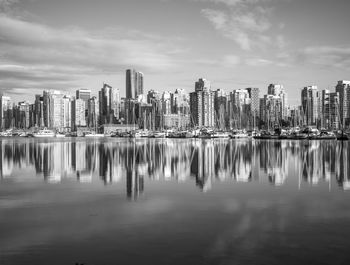 Reflection of buildings in city against sky