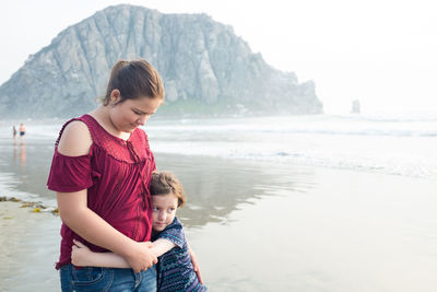 Portrait of mother and son standing on beach