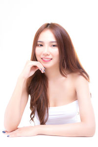 Portrait of beautiful young woman against white background