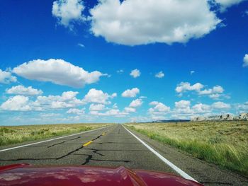 Road amidst landscape against blue sky