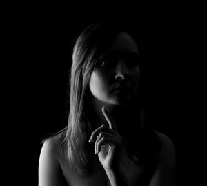 Portrait of beautiful woman against black background