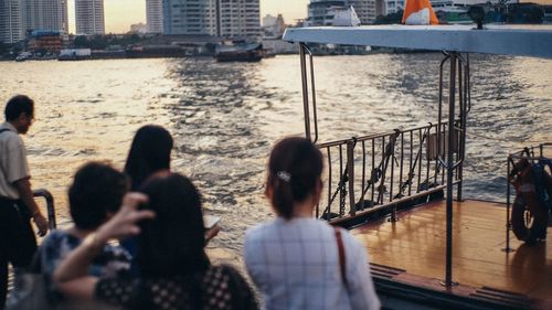 Group of people by river in city 