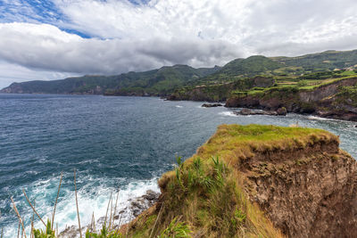 Scenic view of sea and mountains against sky