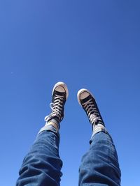 Low section of person against clear blue sky