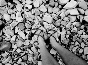 Low section of woman on pebbles at beach