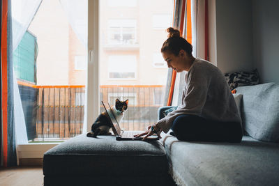 People sitting on a cat looking through window