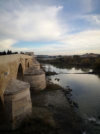 Arch bridge over river against sky