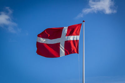 Low angle view of flag against blue sky