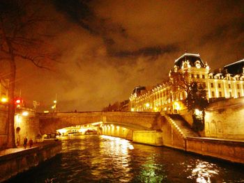 Illuminated bridge over river at night