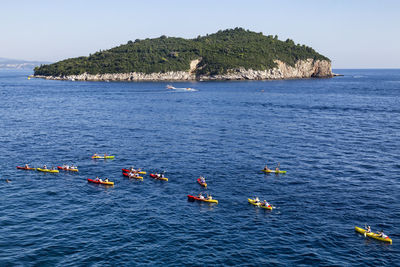 People in sea against sky