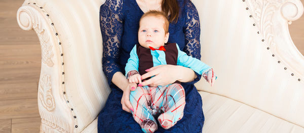 Full length of woman sitting on bed