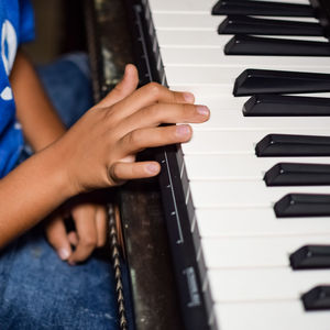 Asian boy playing the synthesizer or piano. cute little kid learning how to play piano