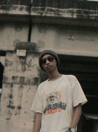 Portrait of young man wearing sunglasses standing outdoors