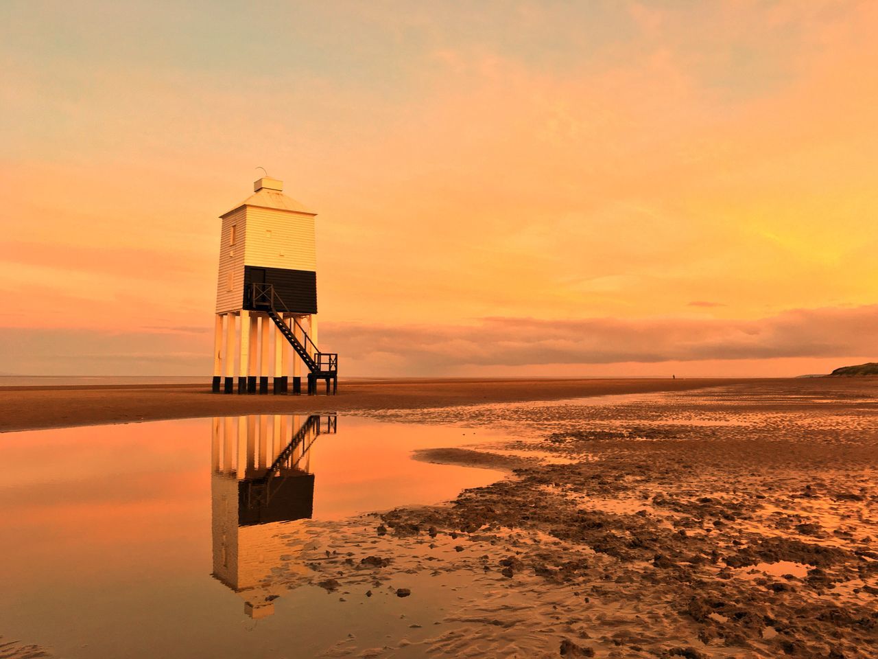 sunset, water, tranquility, sea, tranquil scene, beauty in nature, reflection, scenics, sky, nature, beach, orange color, horizon over water, outdoors, built structure, no people, lifeguard hut, architecture, day