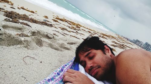 Close-up of man on beach against sky