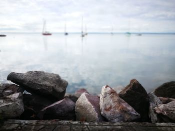 Close-up of rocks in sea against sky