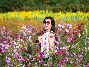 Young woman wearing sunglasses on flower field