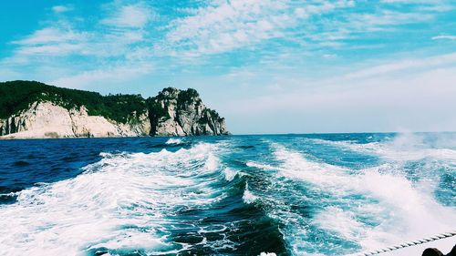 Scenic view of sea and mountain against cloudy sky