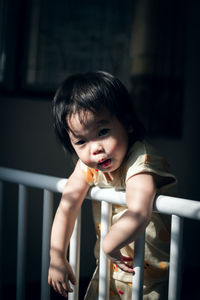 Portrait of cute baby girl in crib