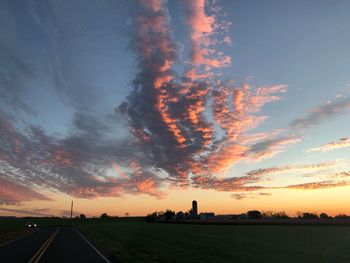 Silhouette landscape against dramatic sky during sunset