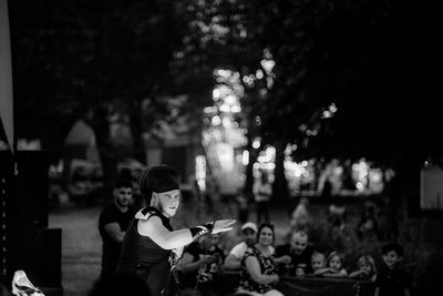 Group of people sitting in city at night